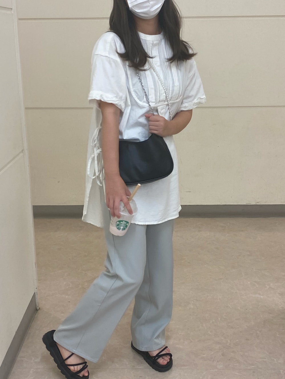 グリーン系のスラックス、ブラック系のサンダル、ホワイト系のシャツ/ブラウスを着用したレディースの夏コーディネートの2枚目の写真