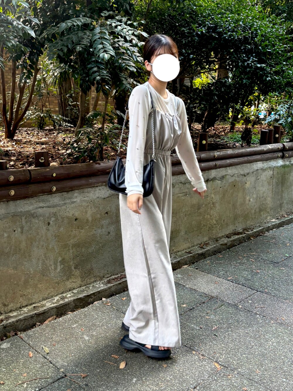 ベージュ系のサロペット/オーバーオール、ホワイト系のTシャツ/カットソー、ブラック系のサンダルを着用したレディースの秋コーディネートの2枚目の写真