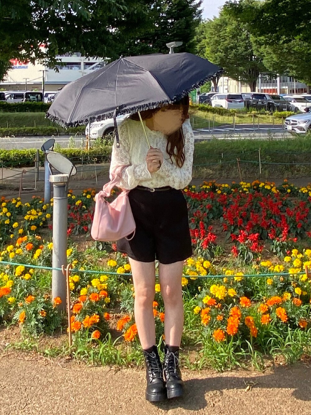 ピンク系のハンドバッグ、ブラック系のその他パンツ、ブラック系のブーツを着用したレディースの春コーディネートの2枚目の写真