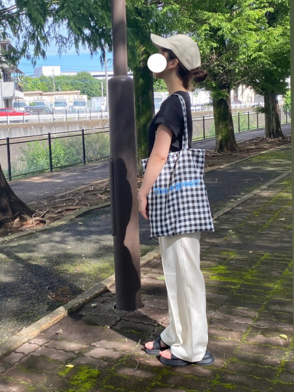 ホワイト系のスラックス、ブラック系のシャツ/ブラウス、ブラック系のエコバッグ/サブバッグを着用したレディースの夏コーディネートの2枚目の写真