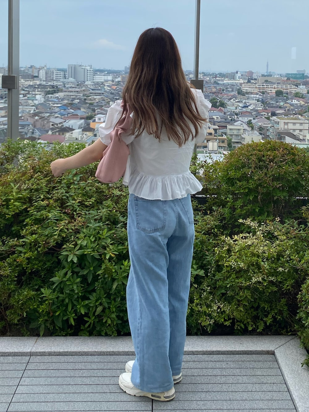ホワイト系のシャツ/ブラウス、ブルー系のデニムパンツ、ベージュ系のスニーカーを着用したレディースの夏コーディネートの2枚目の写真