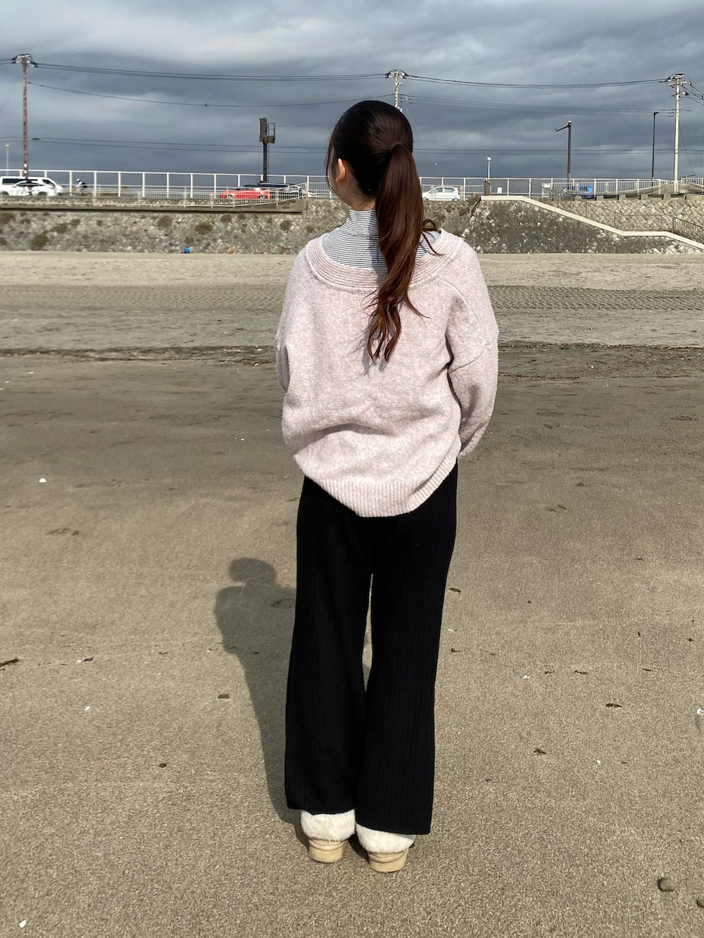 ピンク系のニット/セーター、ホワイト系のTシャツ/カットソー、ブラック系のその他パンツを着用したレディースの冬コーディネートの2枚目の写真