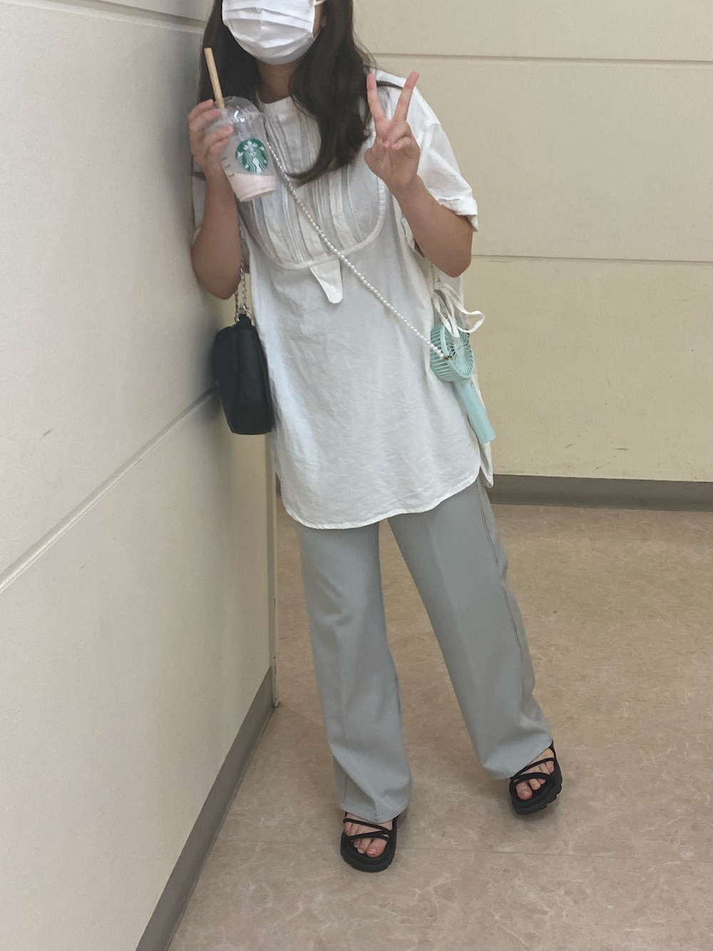 グリーン系のスラックス、ブラック系のサンダル、ホワイト系のシャツ/ブラウスを着用したレディースの夏コーディネートの3枚目の写真