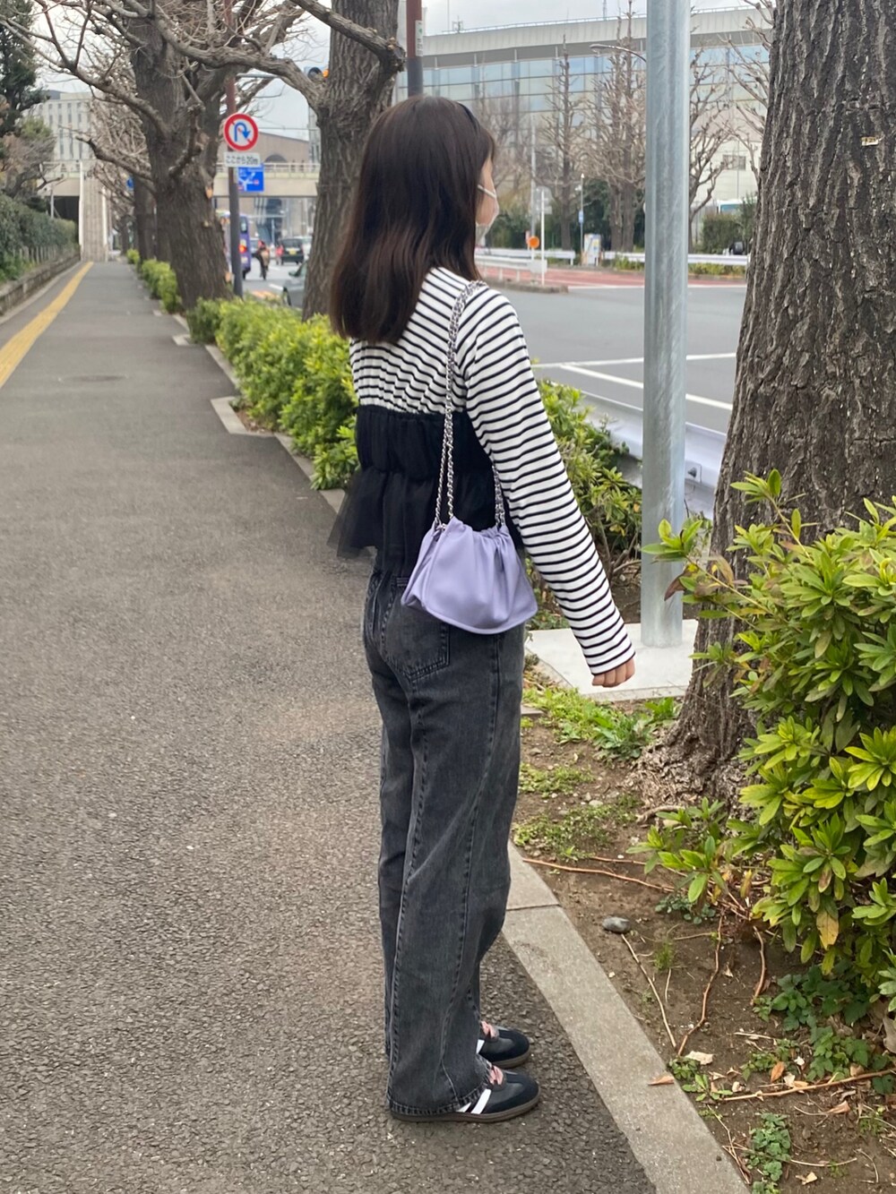 ブラック系のトップス、グレー系のデニムパンツ、パープル系のショルダーバッグを着用したレディースの春コーディネートの2枚目の写真