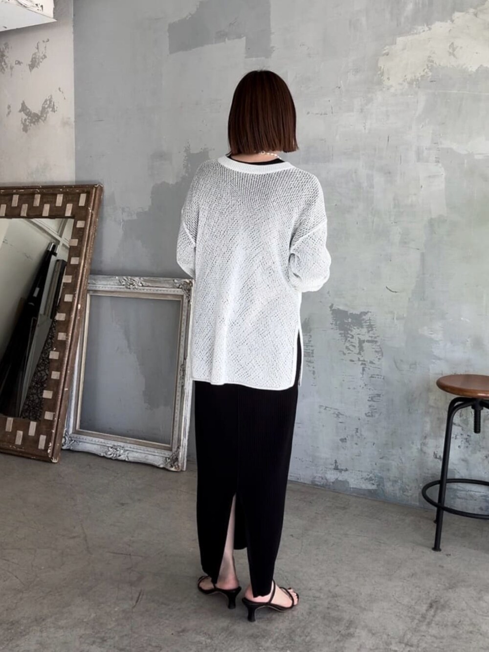 ブラック系のワンピース、ホワイト系のニット/セーター、ブラック系のサンダルを着用したレディースの夏コーディネートの3枚目の写真