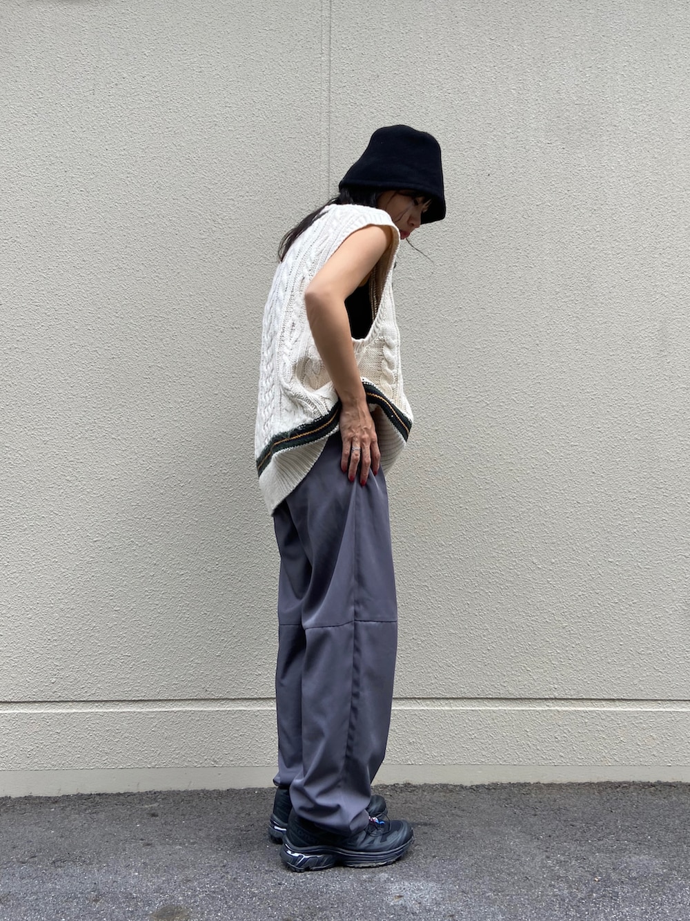 ブラック系のスニーカー、グレー系のその他パンツ、ホワイト系のベストを着用したレディースの秋コーディネートの2枚目の写真