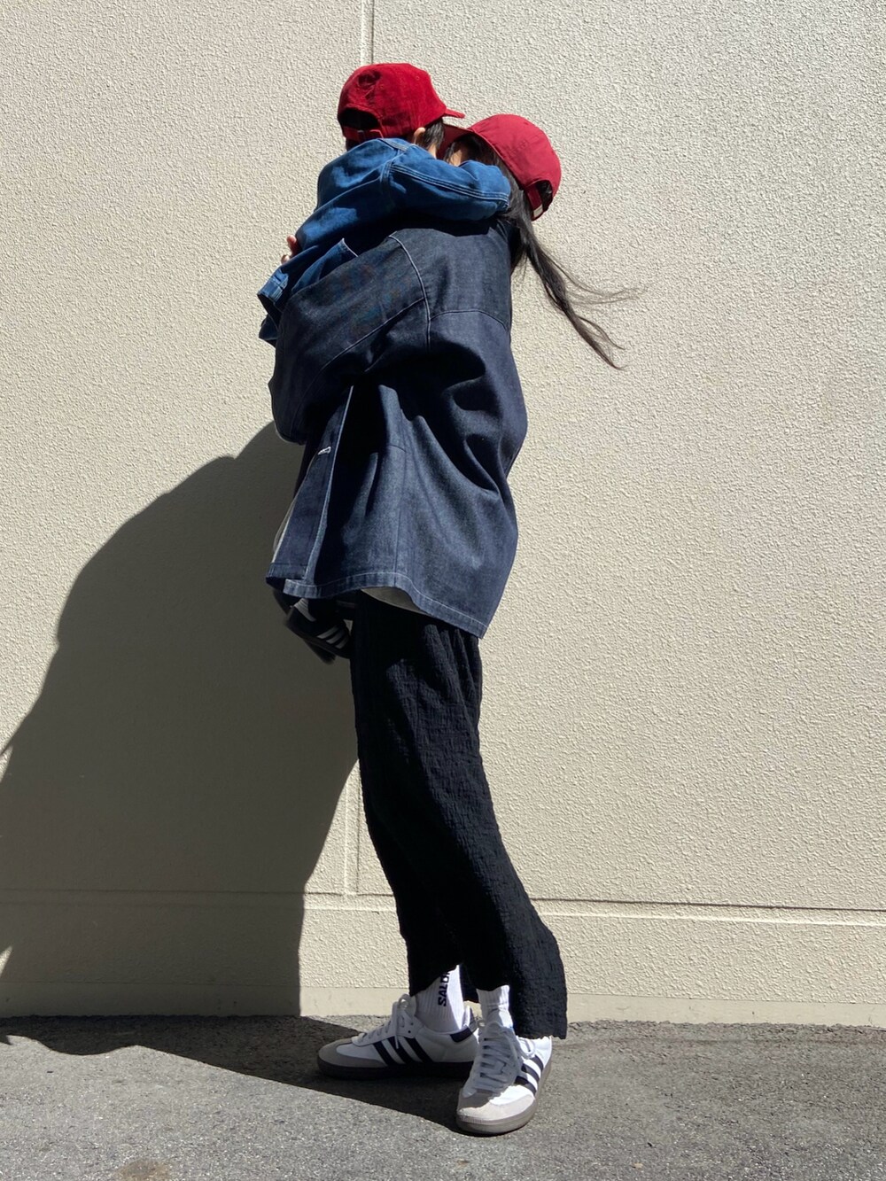 ブラック系のスカート、ホワイト系のスニーカー、ブラック系のシューズを着用したレディースの春コーディネートの2枚目の写真