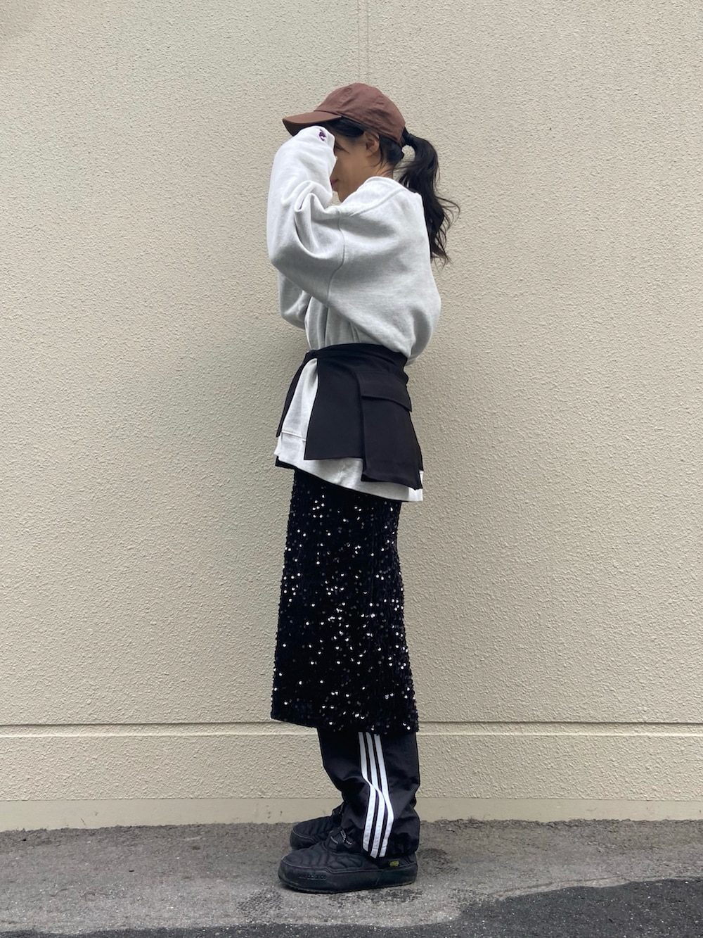 ブラック系のスカート、グレー系のスウェット、ブラック系のカーゴパンツを着用したレディースの冬コーディネートの2枚目の写真