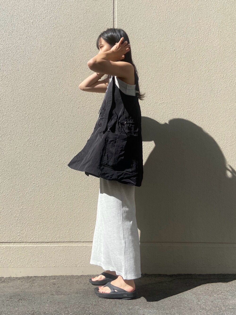 グレー系のワンピース、ブラック系のキャミソール、シルバー系のネックレスを着用したレディースの夏コーディネートの2枚目の写真