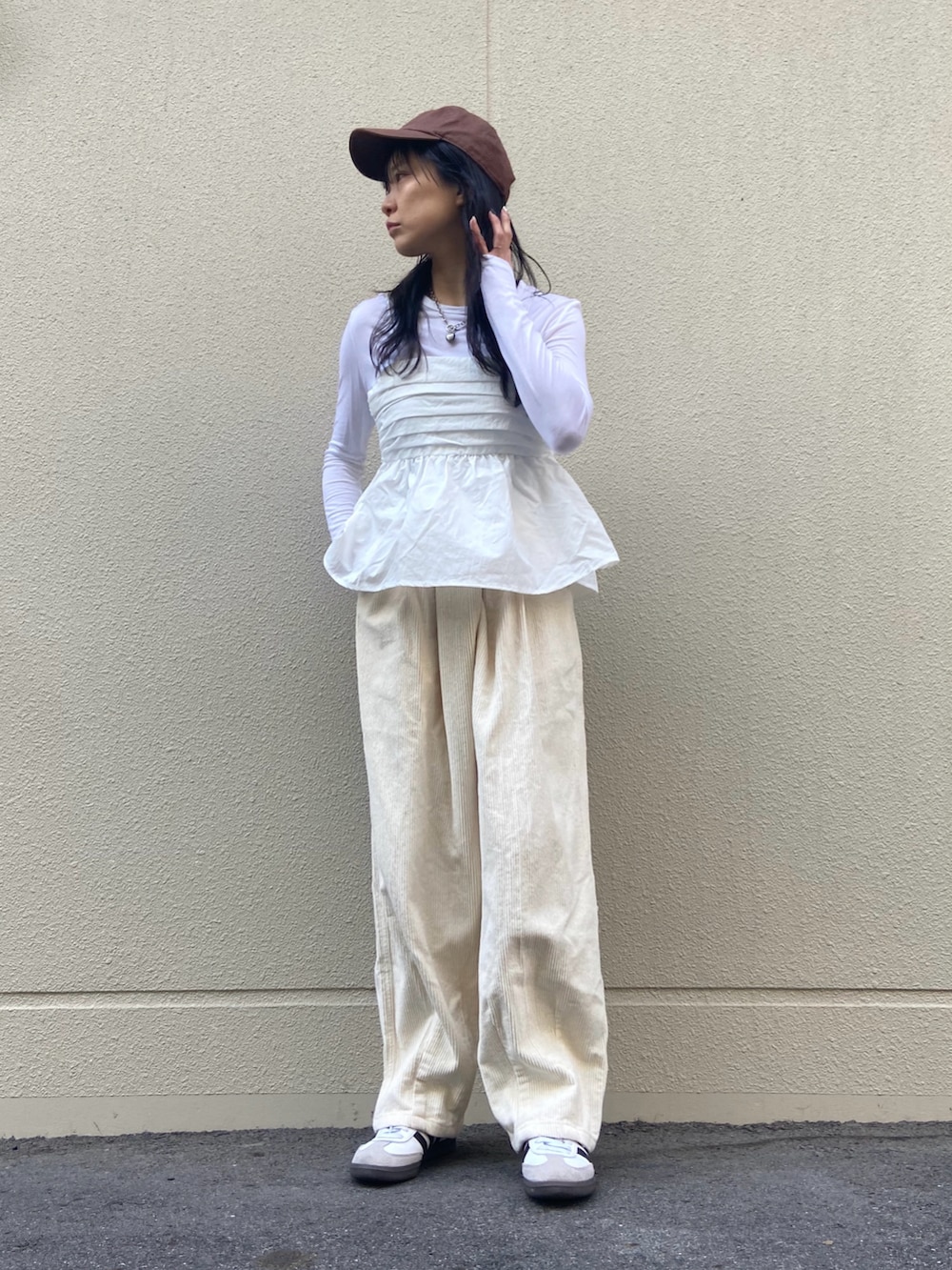 ホワイト系のスニーカー、ホワイト系のパンツ、ホワイト系のキャミソールを着用したレディースの春コーディネートの2枚目の写真