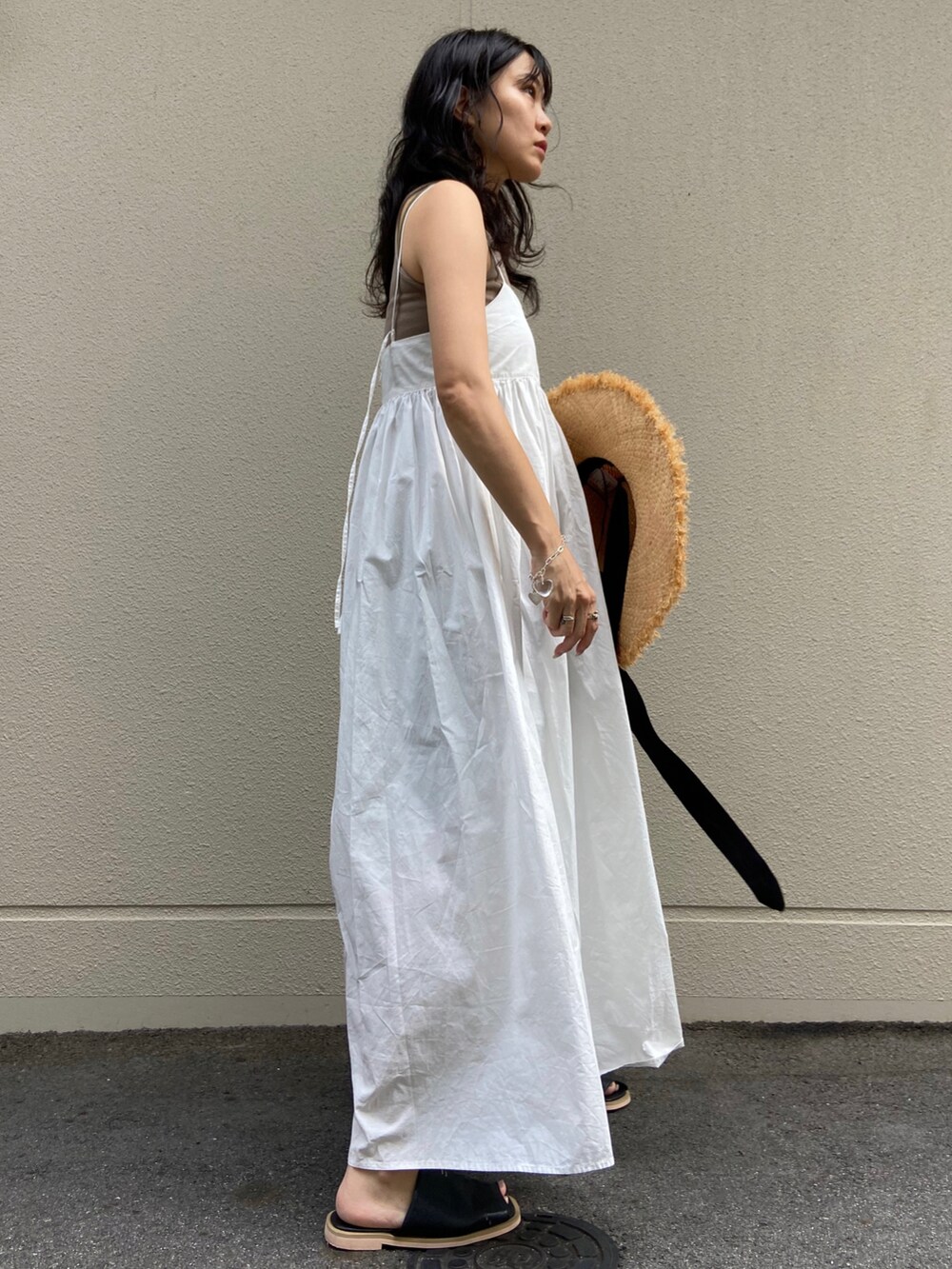 ブラック系のサンダル、ホワイト系のワンピース、ブラック系のタンクトップを着用したレディースの夏コーディネートの3枚目の写真