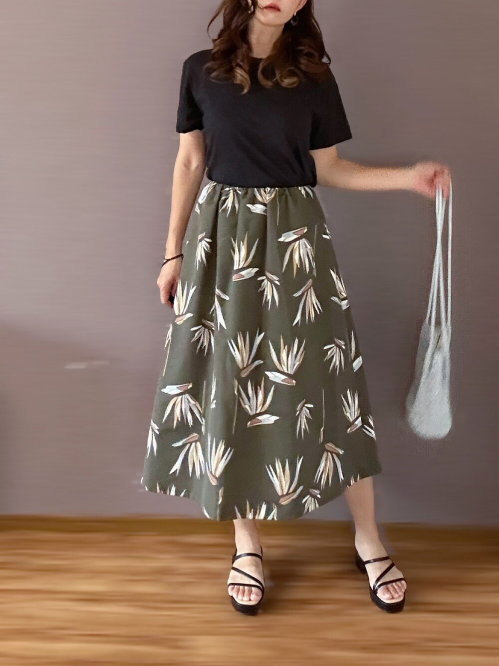 グリーン系のスカートを着用したレディースの夏コーディネートの2枚目の写真