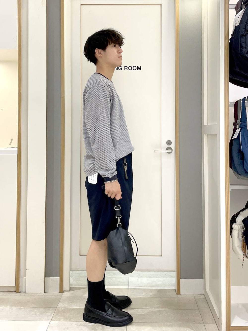 ブラック系のショルダーバッグ、ブルー系のTシャツ/カットソー、グレー系のその他シューズを着用したメンズの秋コーディネートの4枚目の写真