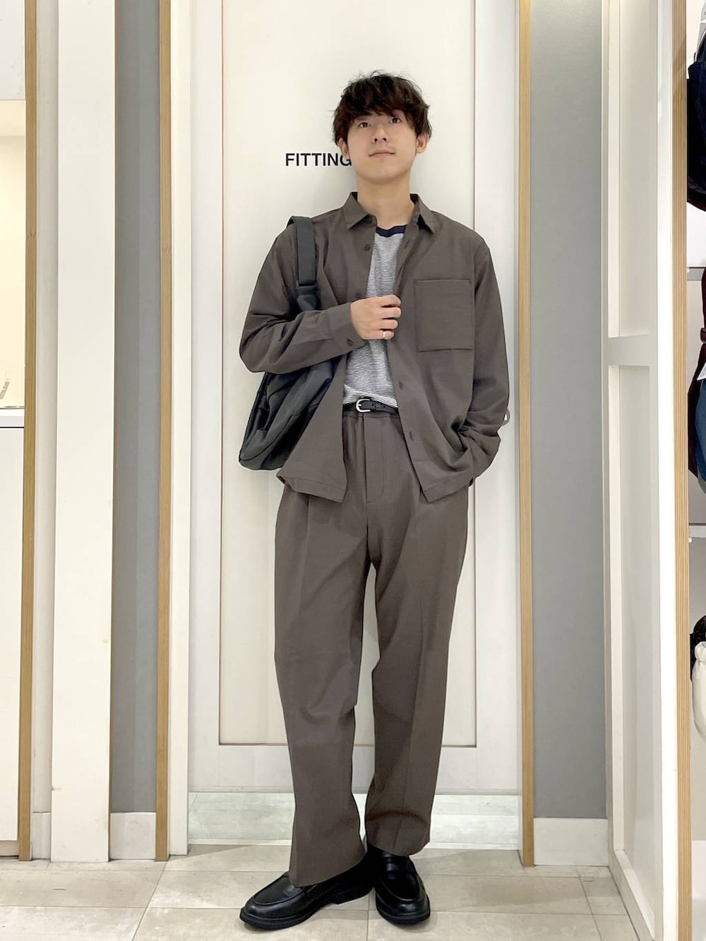 ブルー系のTシャツ/カットソー、ブラウン系のその他パンツ、グレー系のショルダーバッグを着用したメンズの秋コーディネートの2枚目の写真