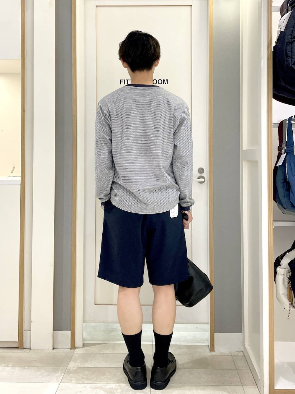 ブラック系のショルダーバッグ、ブルー系のTシャツ/カットソー、グレー系のその他シューズを着用したメンズの秋コーディネートの5枚目の写真