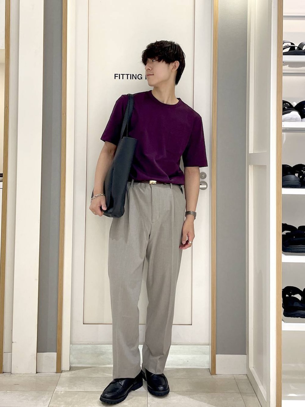 ブラック系のトートバッグ、ブラウン系のスラックス、グレー系のその他シューズを着用したメンズの夏コーディネートの2枚目の写真