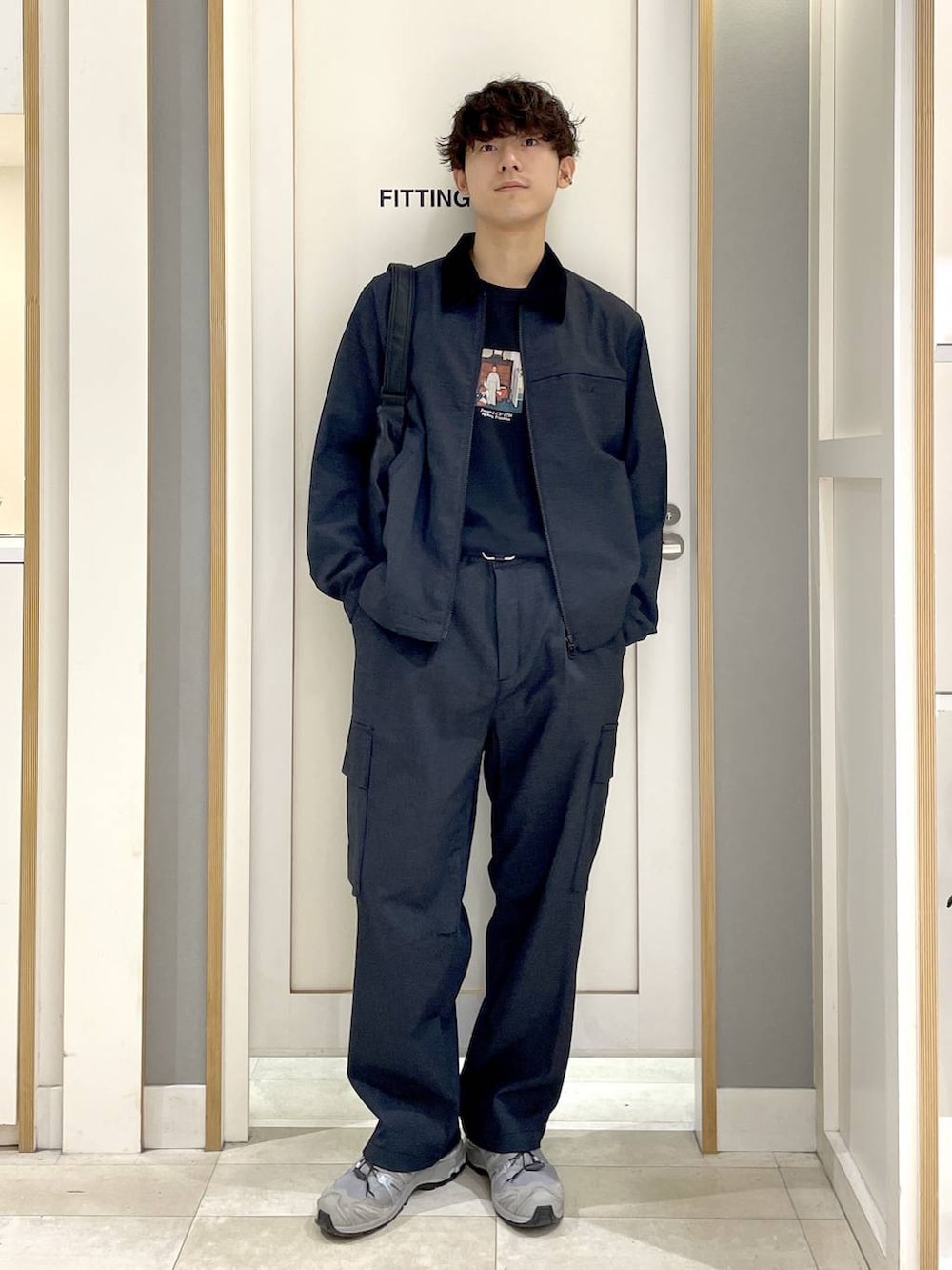 ブラック系のTシャツ/カットソー、ブラック系のショルダーバッグ、ブルー系のデニムパンツを着用したメンズの秋コーディネートの5枚目の写真