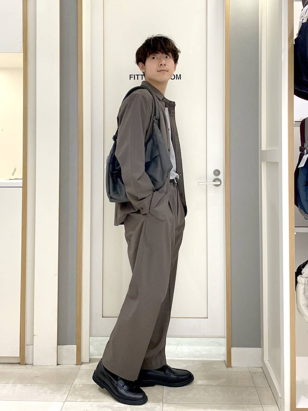 ブルー系のTシャツ/カットソー、ブラウン系のその他パンツ、グレー系のショルダーバッグを着用したメンズの秋コーディネートの4枚目の写真