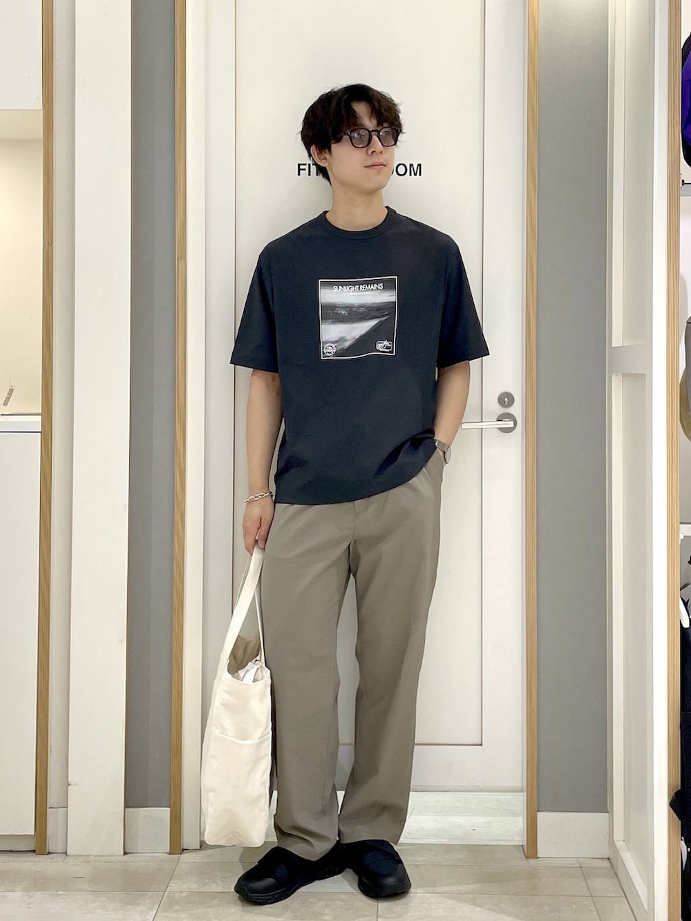 ホワイト系のトートバッグ、グレー系のTシャツ/カットソー、ブラウン系のその他パンツを着用したメンズの夏コーディネートの3枚目の写真