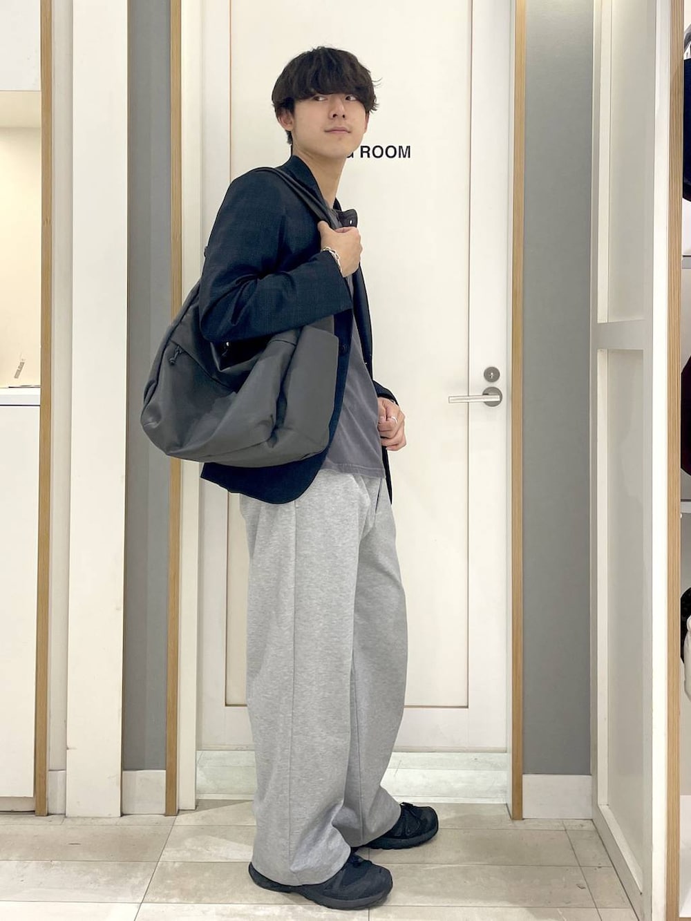 グレー系のその他パンツ、グレー系のTシャツ/カットソー、ブラック系のスニーカーを着用したメンズの秋コーディネートの3枚目の写真