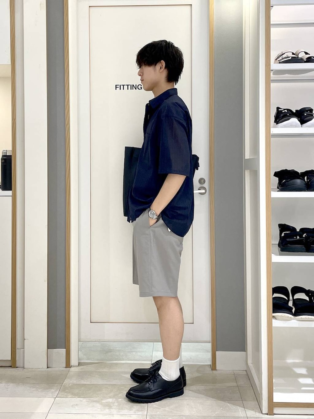 ブラック系のトートバッグ、グレー系のその他シューズ、ブルー系のシャツ/ブラウスを着用したメンズの夏コーディネートの5枚目の写真