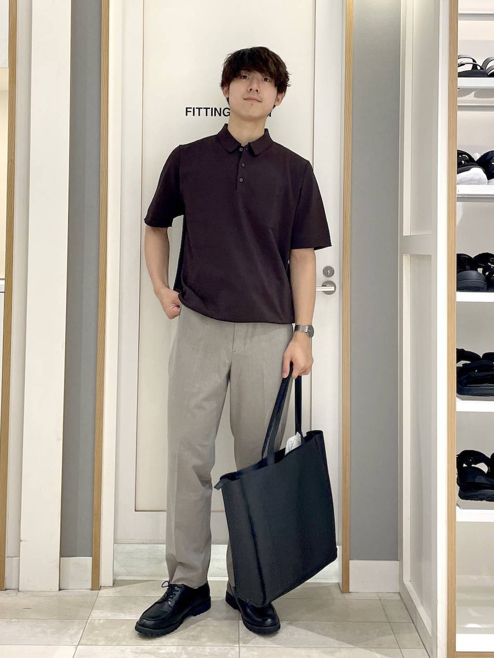 ブラック系のトートバッグ、ブラウン系のスラックス、グレー系のその他シューズを着用したメンズの夏コーディネートの2枚目の写真