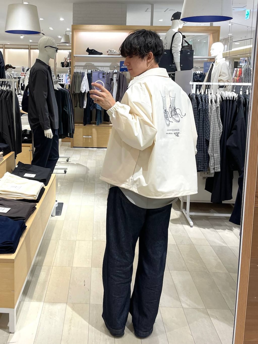 ブラック系のスニーカー、グレー系のシャツ/ブラウス、ブルー系のデニムパンツを着用したメンズの秋コーディネートの2枚目の写真