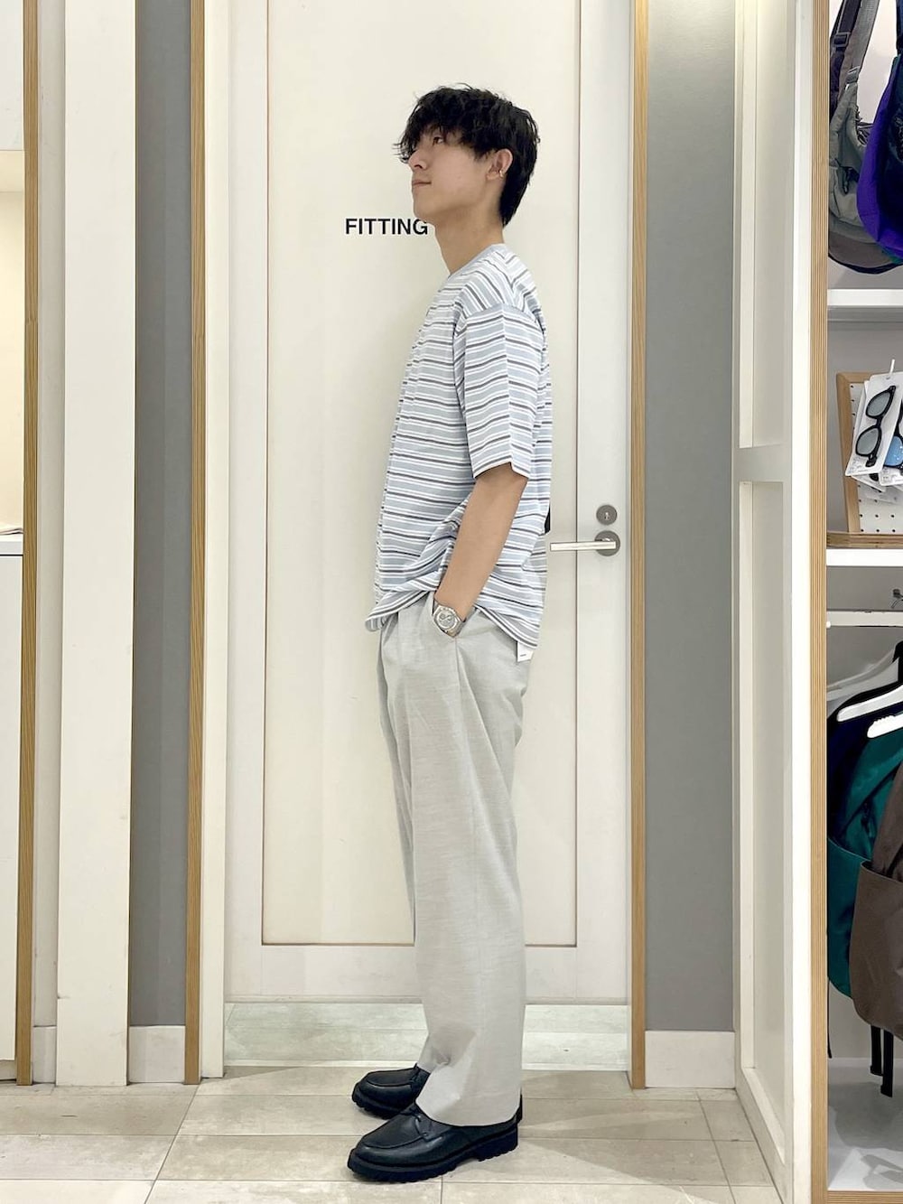 グレー系のショルダーバッグ、ホワイト系のスラックス、グレー系のその他シューズを着用したメンズの夏コーディネートの4枚目の写真
