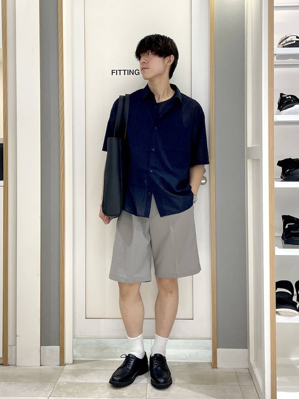 ブラック系のトートバッグ、グレー系のその他シューズ、ブルー系のシャツ/ブラウスを着用したメンズの夏コーディネートの4枚目の写真