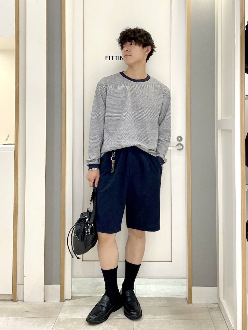 ブラック系のショルダーバッグ、ブルー系のTシャツ/カットソー、グレー系のその他シューズを着用したメンズの秋コーディネートの3枚目の写真