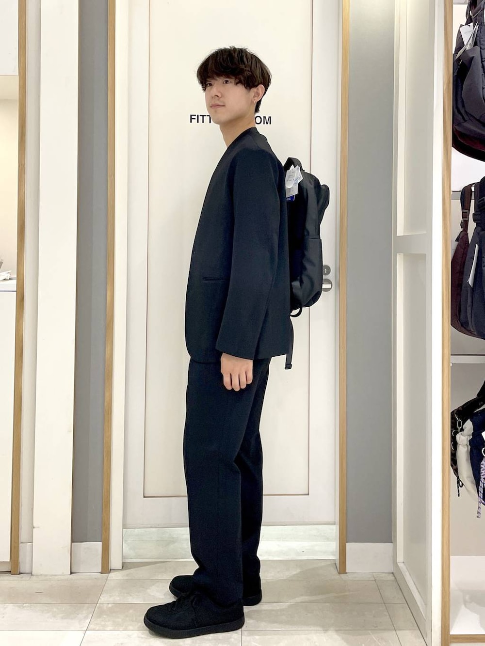 ブラック系のスニーカー、グレー系のバックパック/リュック、ブルー系のその他パンツを着用したメンズの秋コーディネートの3枚目の写真