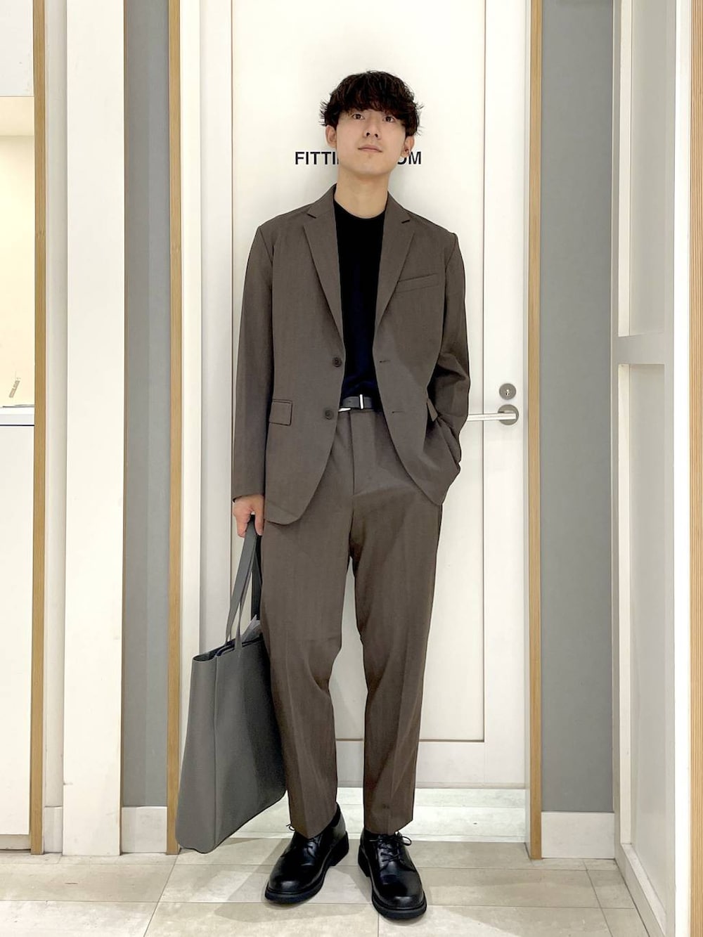 ブラック系のトートバッグ、グレー系のその他シューズ、ブラック系のTシャツ/カットソーを着用したメンズの夏コーディネートの3枚目の写真
