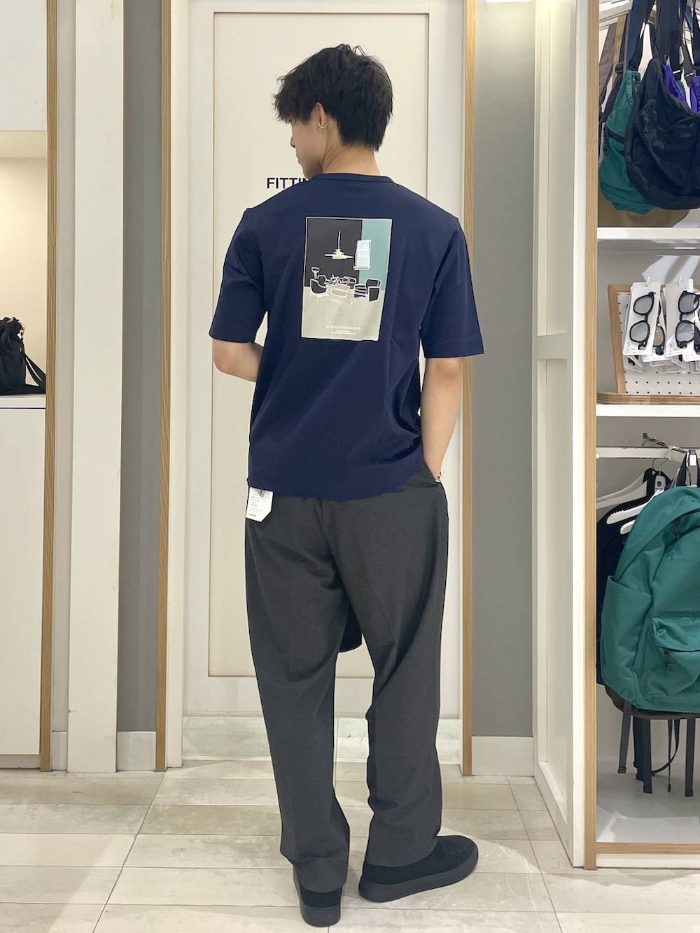 グレー系のその他シューズ、グレー系のスラックス、ブルー系のTシャツ/カットソーを着用したメンズの春コーディネートの2枚目の写真