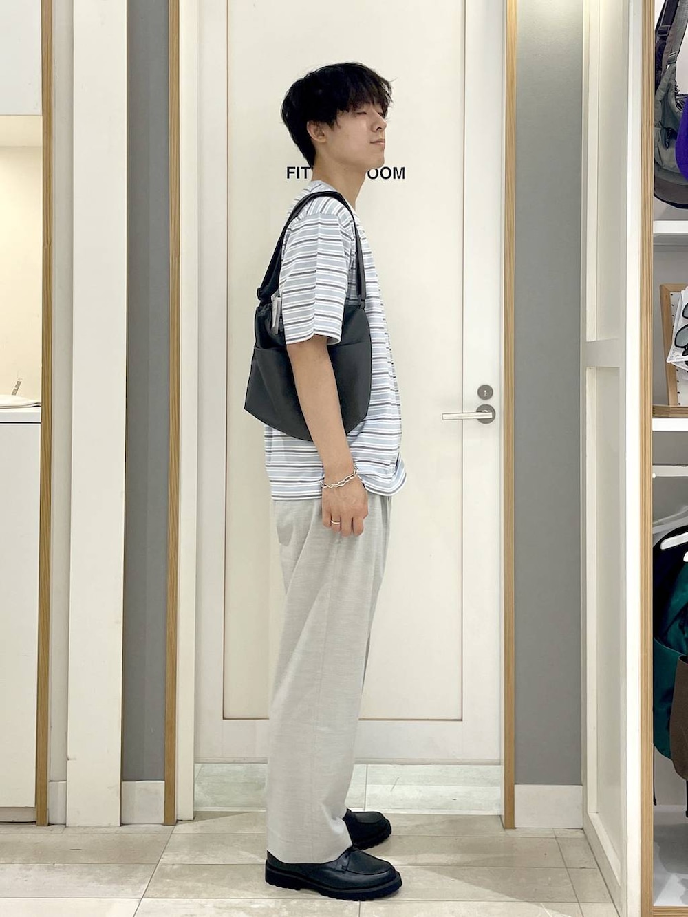 グレー系のショルダーバッグ、ホワイト系のスラックス、グレー系のその他シューズを着用したメンズの夏コーディネートの3枚目の写真