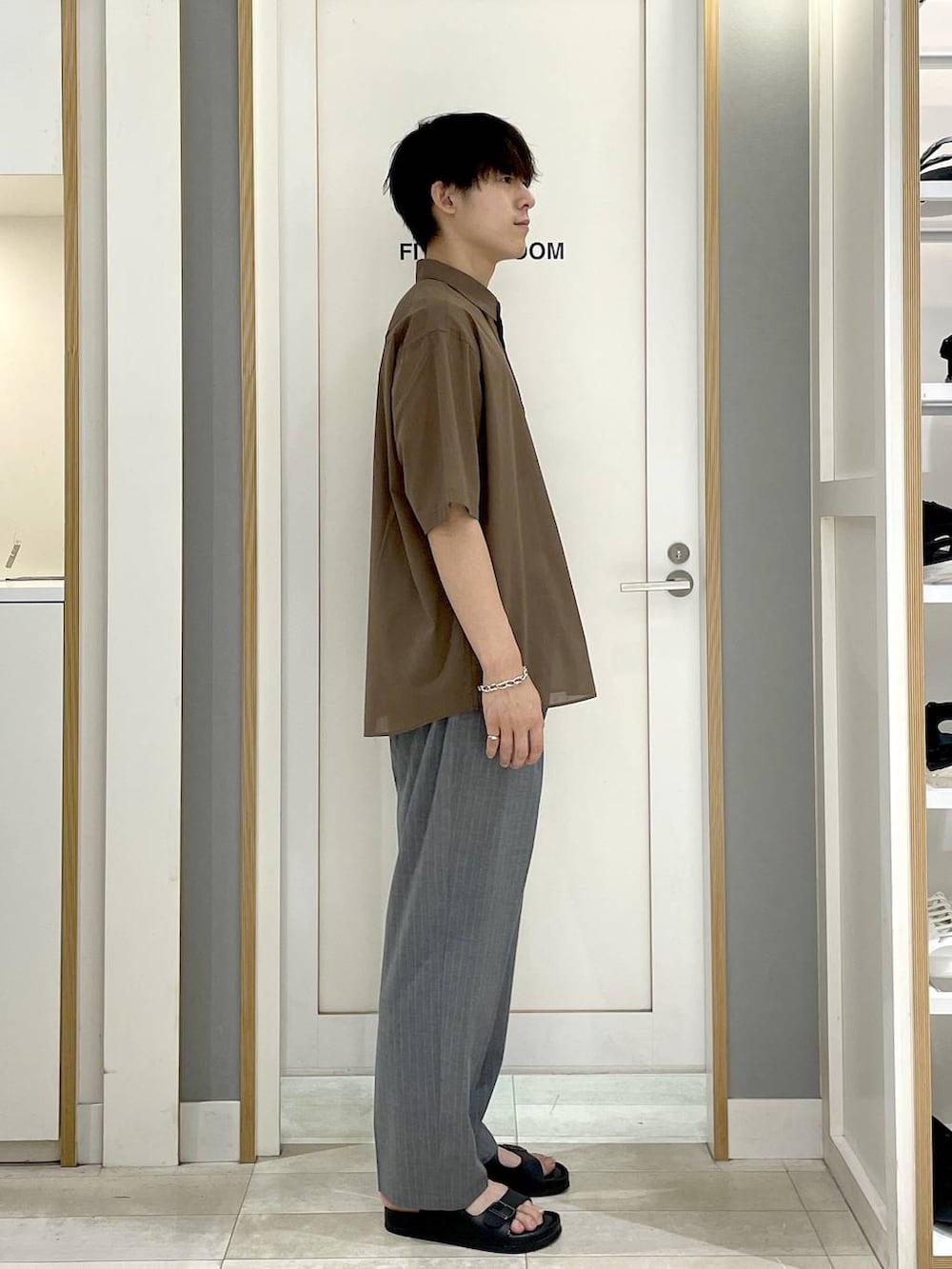グレー系のスラックス、ブラウン系のシャツ/ブラウス、ブラック系のサンダルを着用したメンズの夏コーディネートの3枚目の写真