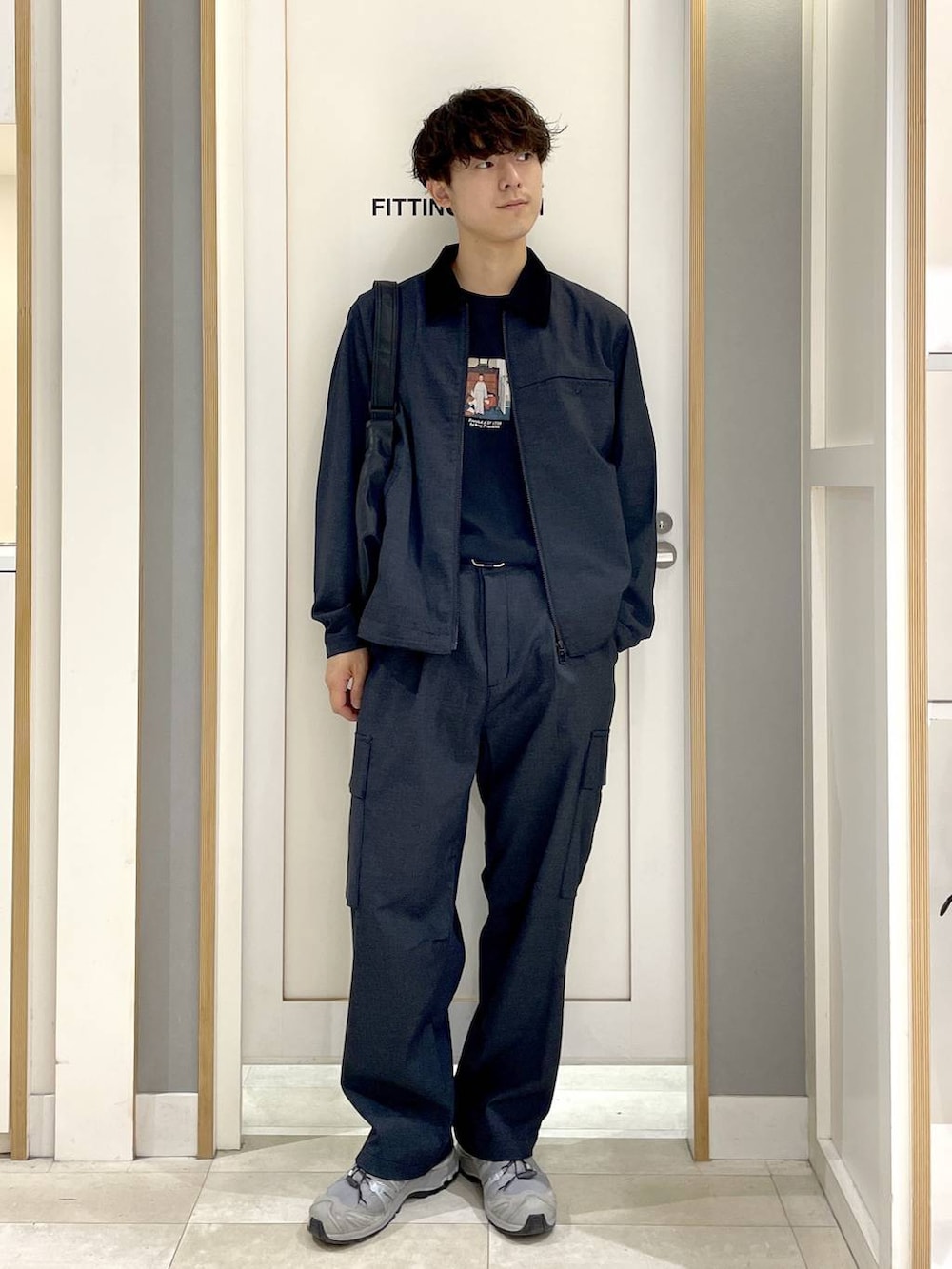 ブラック系のTシャツ/カットソー、ブラック系のショルダーバッグ、ブルー系のデニムパンツを着用したメンズの秋コーディネートの2枚目の写真