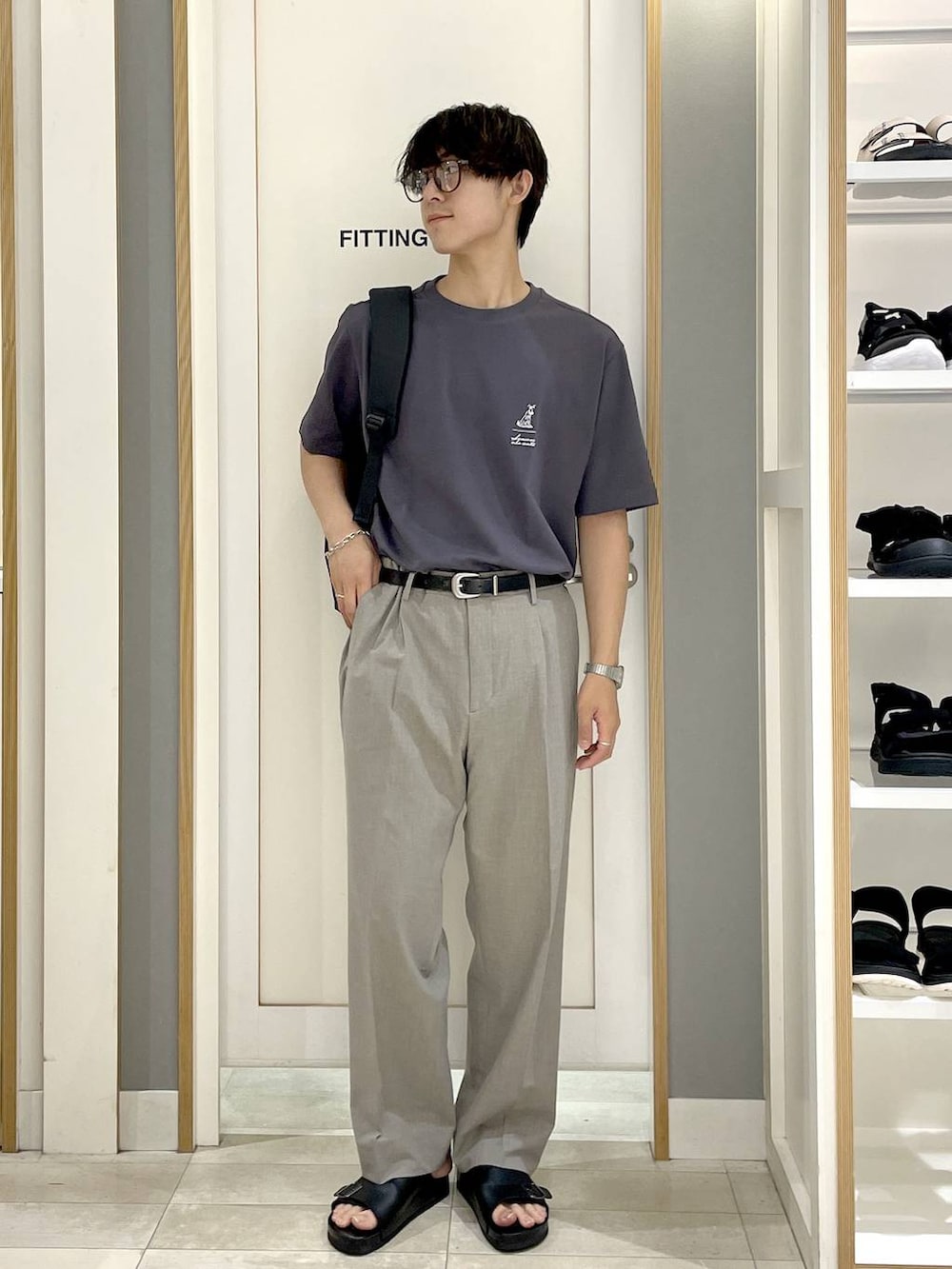 ブラック系のバックパック/リュック、ブラウン系のスラックス、グレー系のTシャツ/カットソーを着用したメンズの夏コーディネートの2枚目の写真