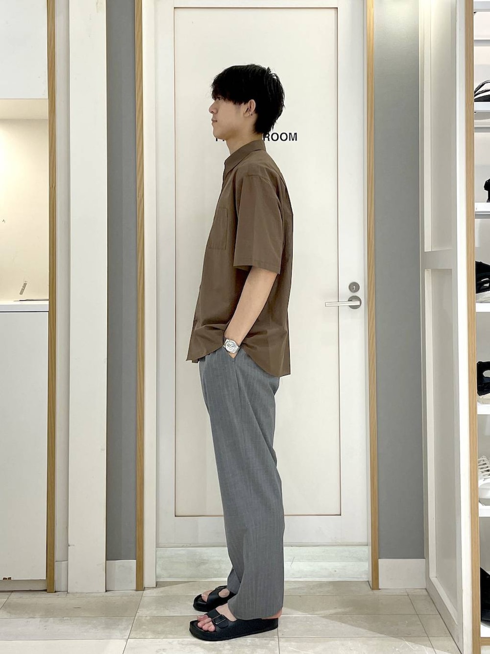 グレー系のスラックス、ブラウン系のシャツ/ブラウス、ブラック系のサンダルを着用したメンズの夏コーディネートの4枚目の写真