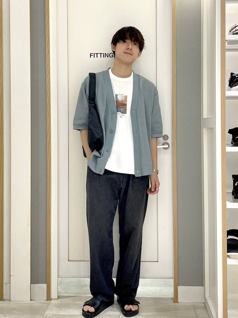 ブラック系のショルダーバッグ、ホワイト系のTシャツ/カットソー、グレー系のデニムパンツを着用したメンズの夏コーディネートの2枚目の写真