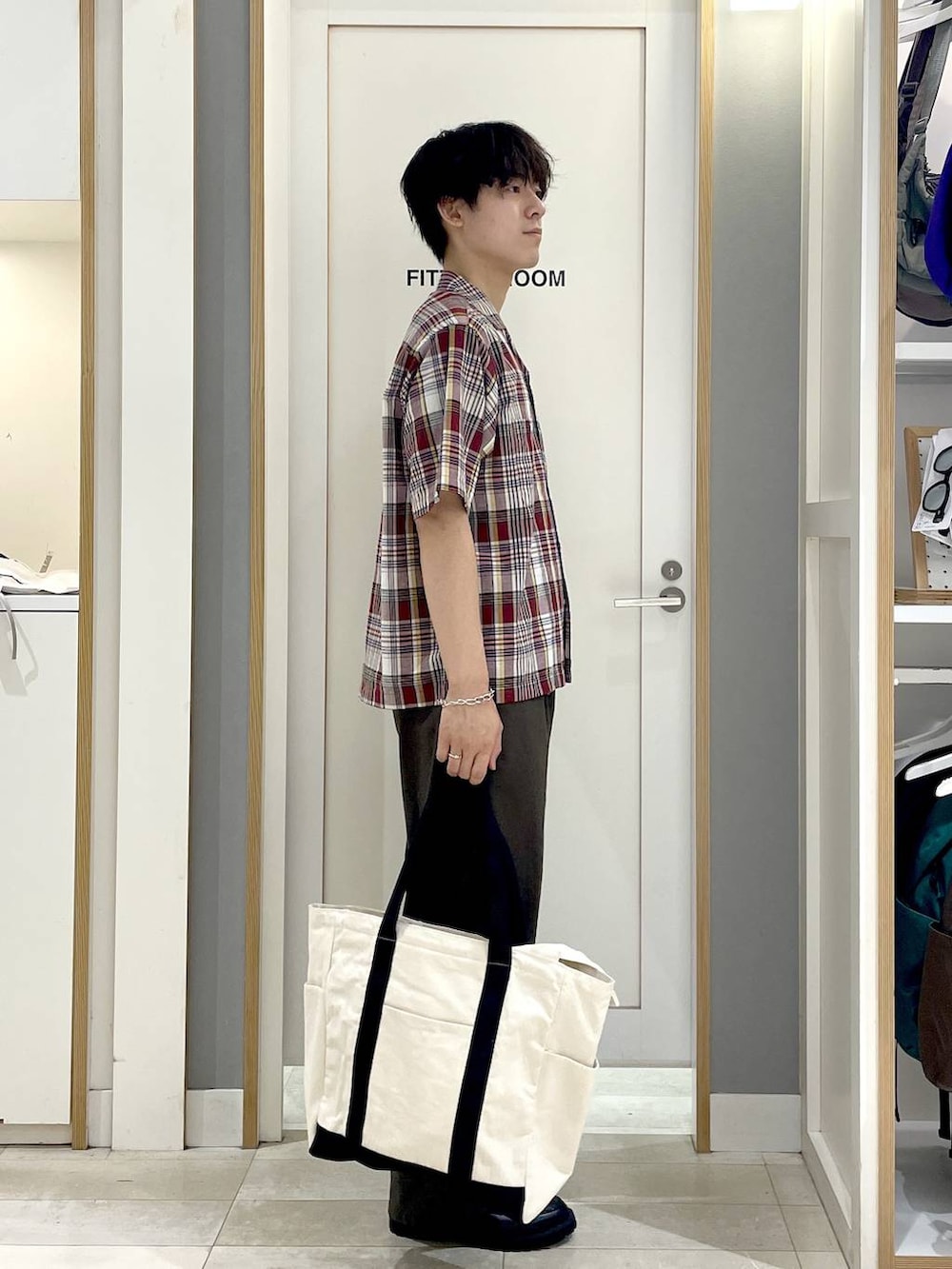 ホワイト系のトートバッグ、ブラウン系のその他パンツ、グレー系のその他シューズを着用したメンズの夏コーディネートの3枚目の写真