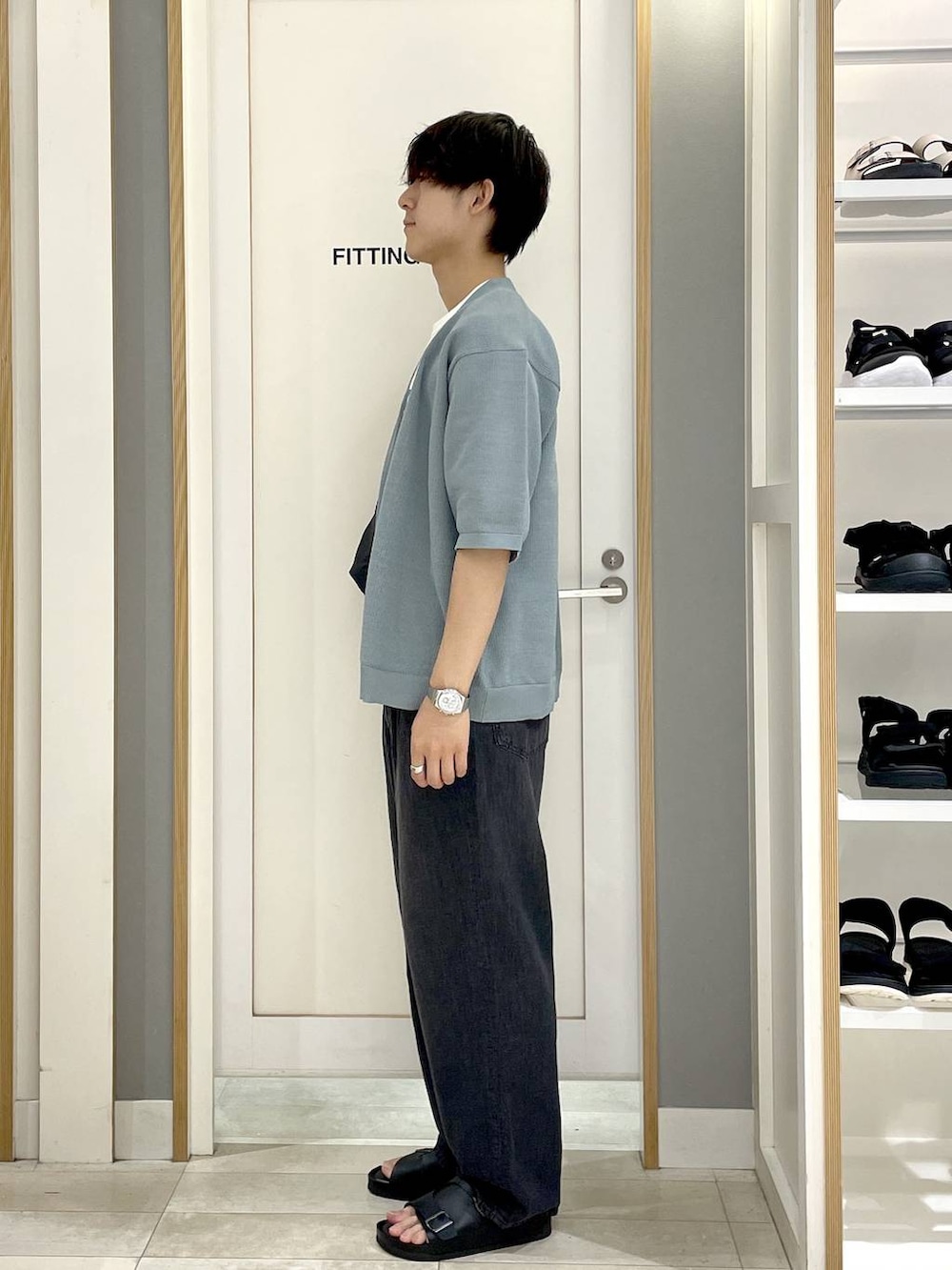 ブラック系のショルダーバッグ、ホワイト系のTシャツ/カットソー、グレー系のデニムパンツを着用したメンズの夏コーディネートの5枚目の写真