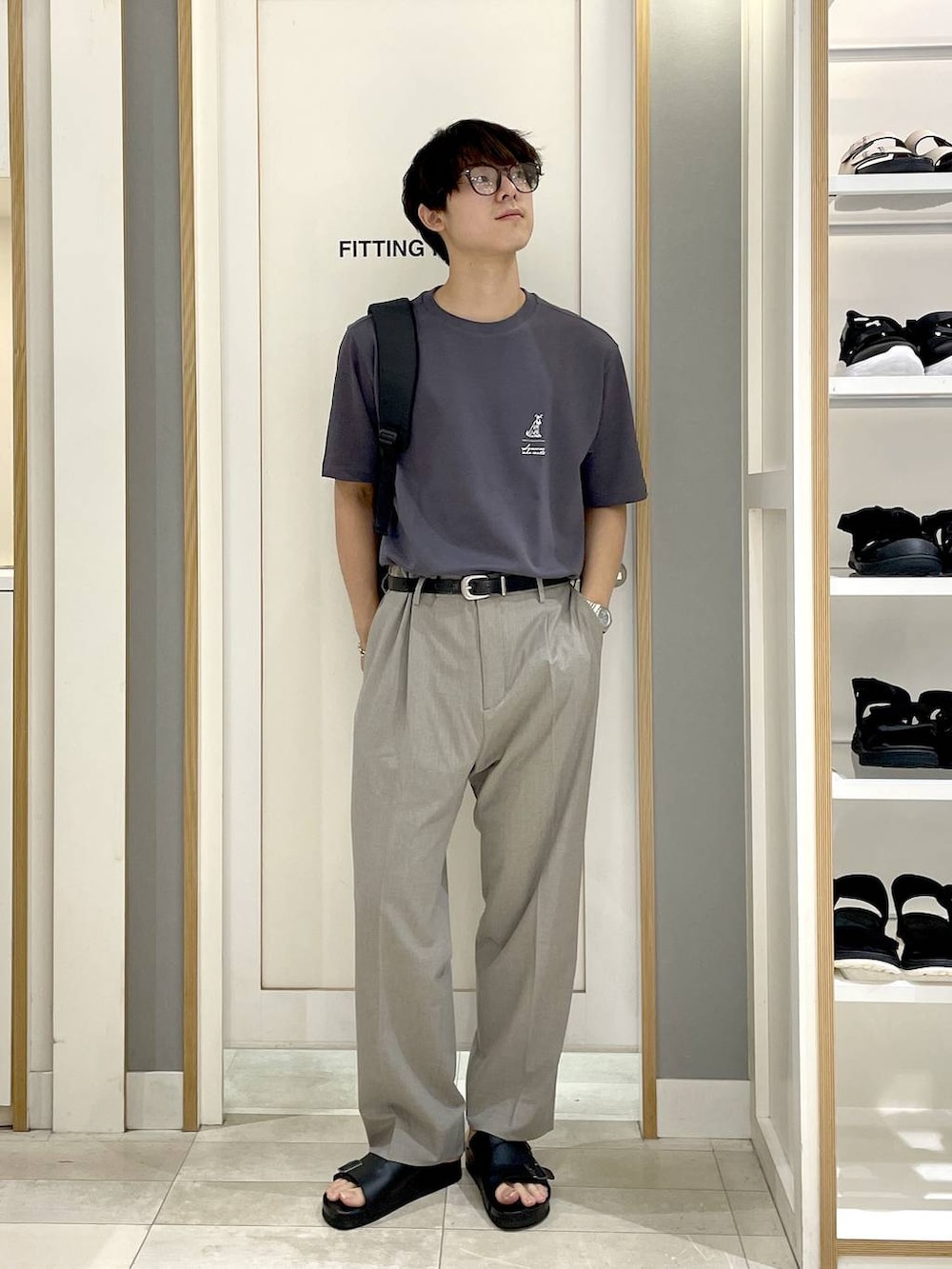 ブラック系のバックパック/リュック、ブラウン系のスラックス、グレー系のTシャツ/カットソーを着用したメンズの夏コーディネートの3枚目の写真