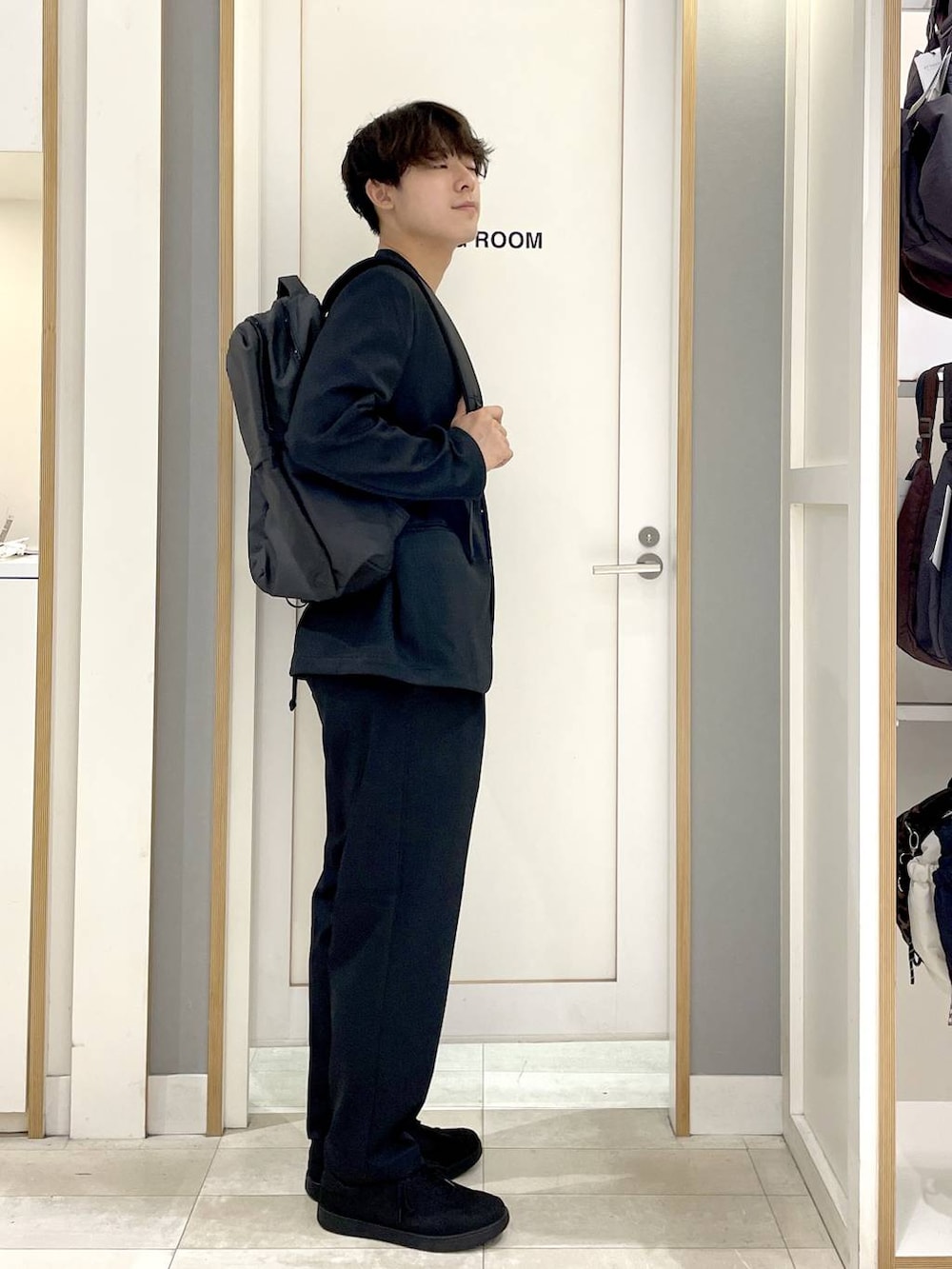 ブラック系のスニーカー、グレー系のバックパック/リュック、ブルー系のその他パンツを着用したメンズの秋コーディネートの4枚目の写真