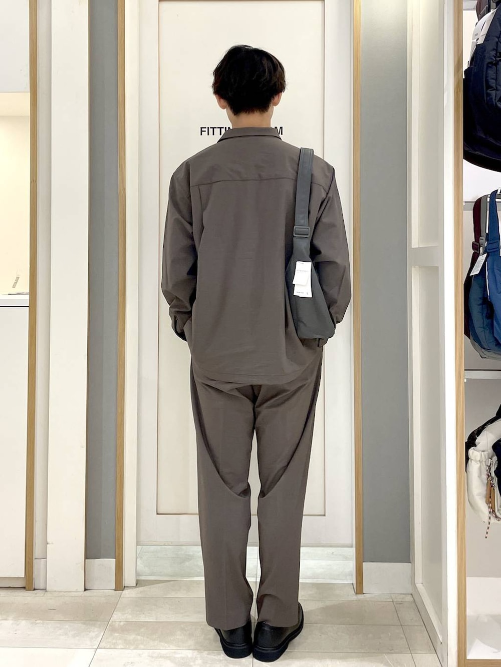 ブルー系のTシャツ/カットソー、ブラウン系のその他パンツ、グレー系のショルダーバッグを着用したメンズの秋コーディネートの6枚目の写真