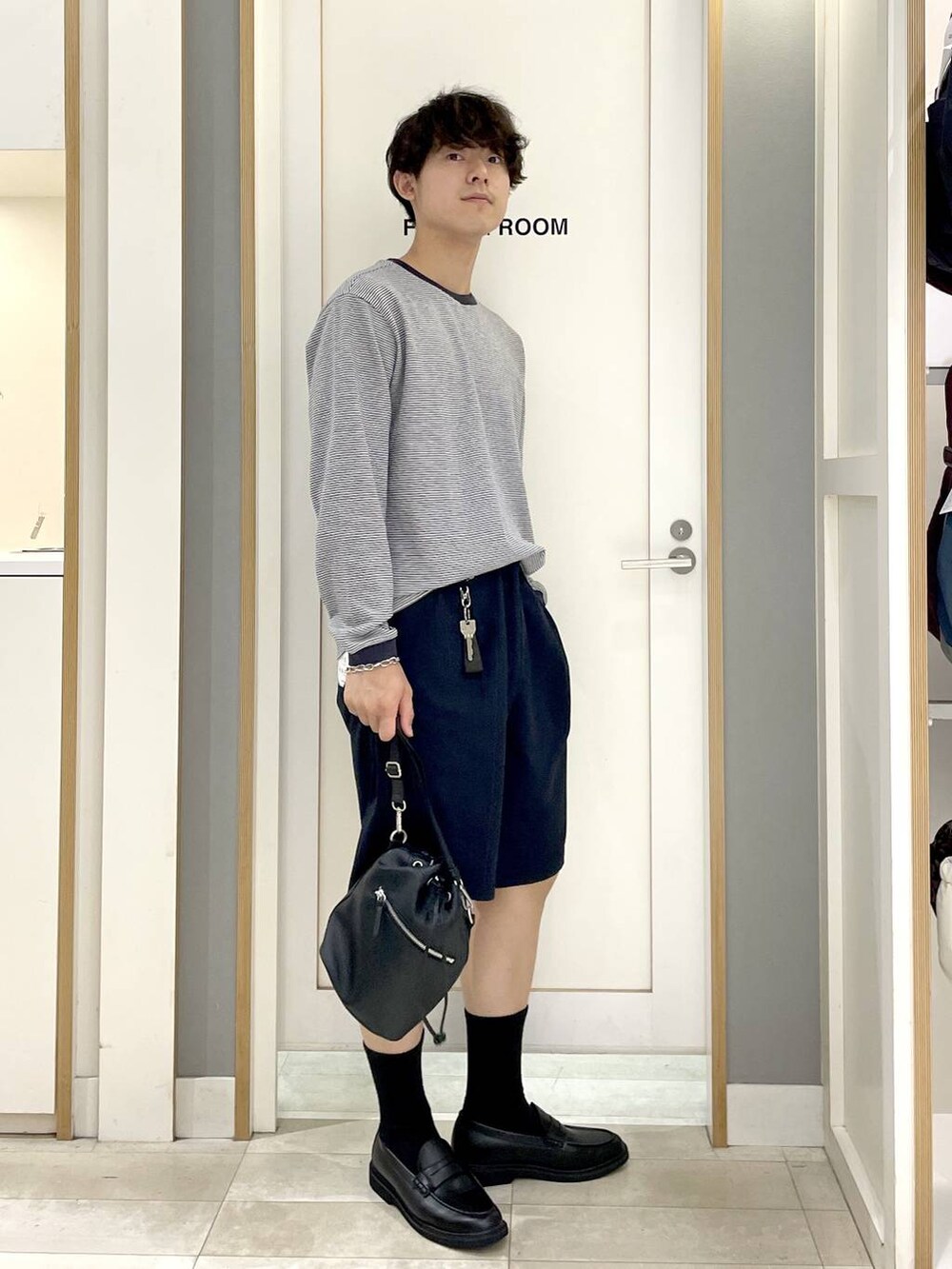 ブラック系のショルダーバッグ、ブルー系のTシャツ/カットソー、グレー系のその他シューズを着用したメンズの秋コーディネートの2枚目の写真
