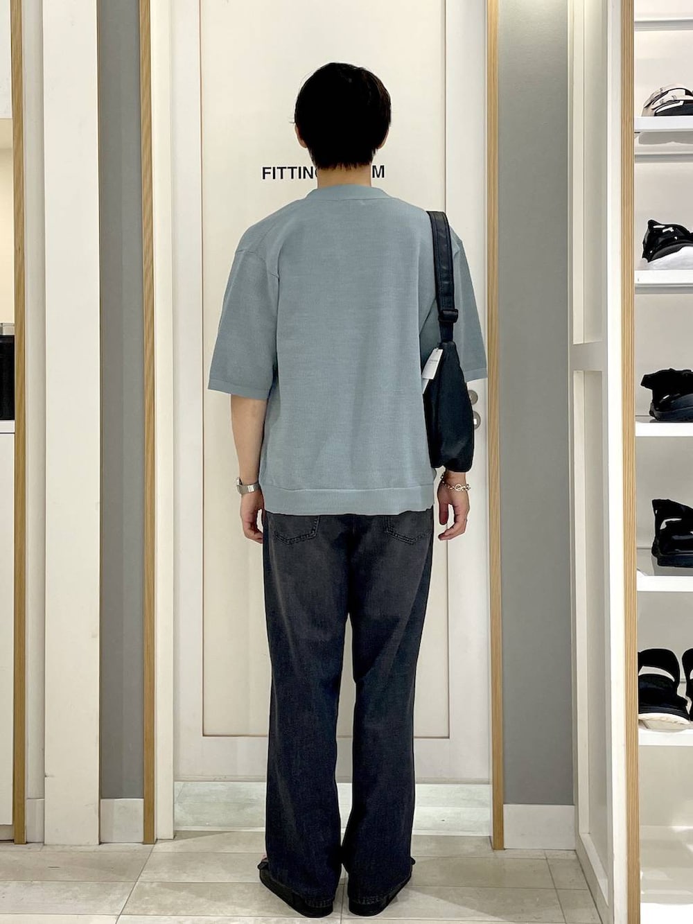 ブラック系のショルダーバッグ、ホワイト系のTシャツ/カットソー、グレー系のデニムパンツを着用したメンズの夏コーディネートの6枚目の写真