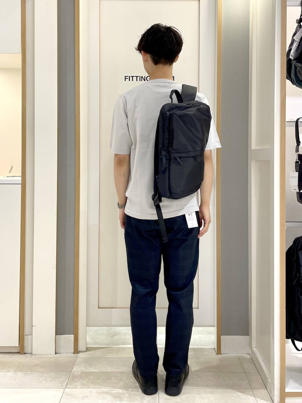 ブラック系のバックパック/リュック、グレー系のその他シューズ、グレー系のTシャツ/カットソーを着用したメンズの秋コーディネートの4枚目の写真