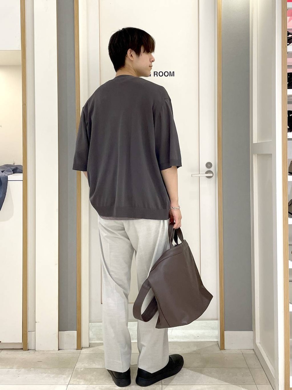 グレー系のその他シューズ、ホワイト系のスラックス、ベージュ系のTシャツ/カットソーを着用したメンズの夏コーディネートの6枚目の写真