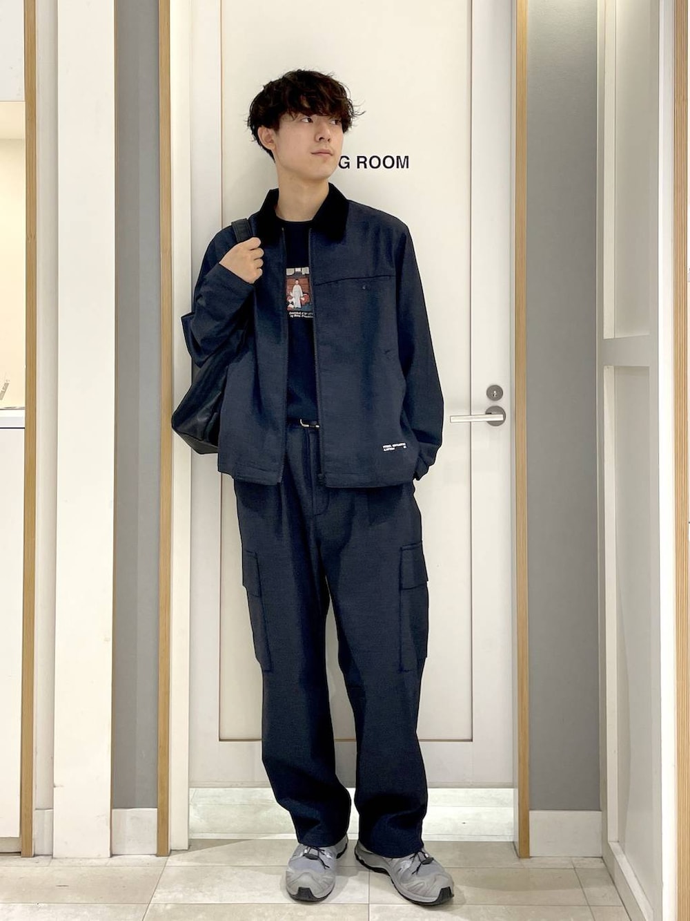 ブラック系のTシャツ/カットソー、ブラック系のショルダーバッグ、ブルー系のデニムパンツを着用したメンズの秋コーディネートの3枚目の写真