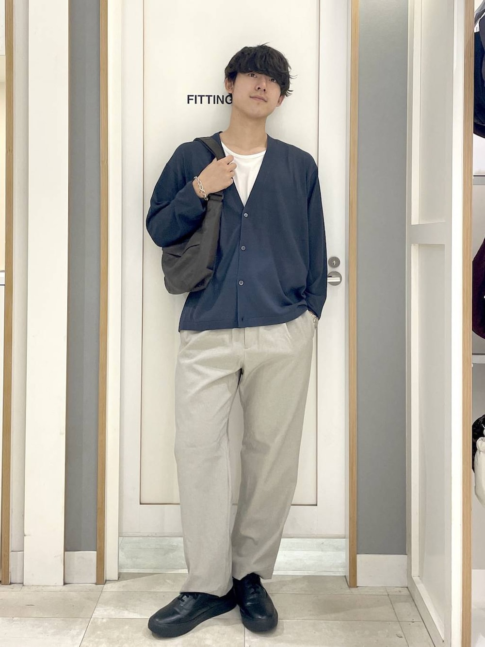グレー系のその他シューズ、グレー系のショルダーバッグ、ブルー系のカーディガン/ボレロを着用したメンズの秋コーディネートの2枚目の写真